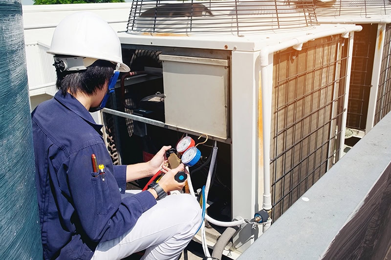 Why Is a Commercial AC Tune-Up Important? A technician working on an air conditioning unit.