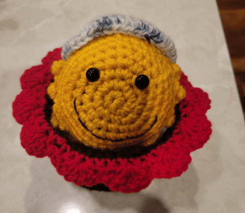 Sunflower bowl crocheted and sitting on table.